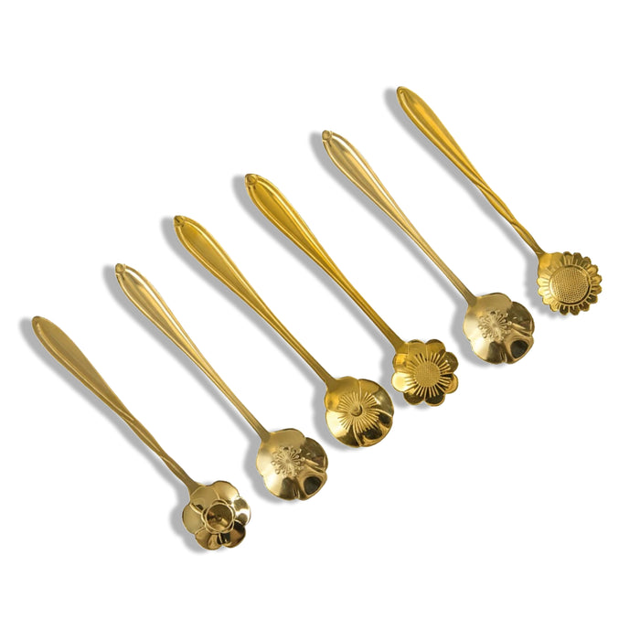 Diverse gouden dessertlepels in de vorm van een bloem.