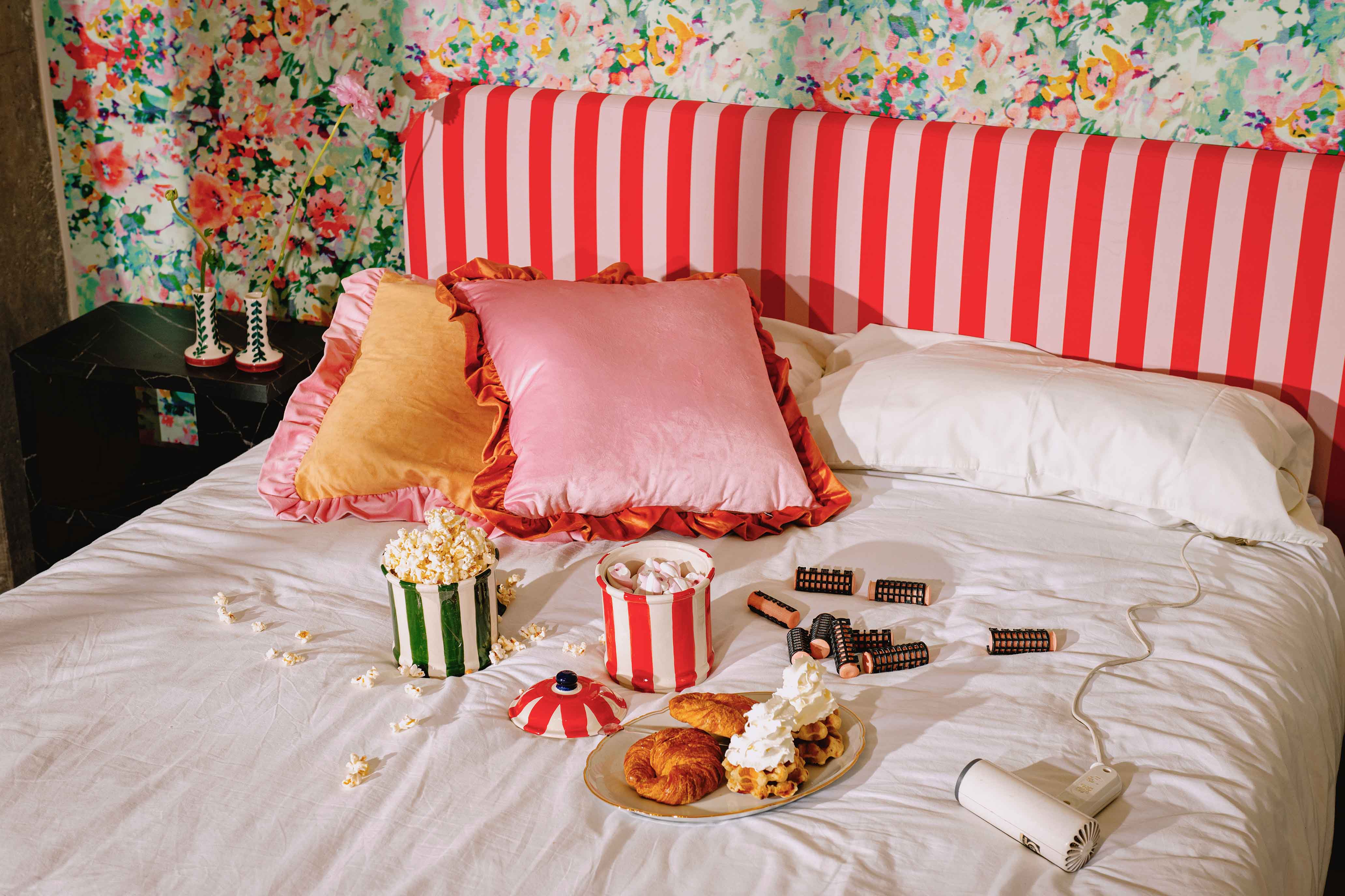 Chambre aux coussins roses et tête de lit rayée rouge