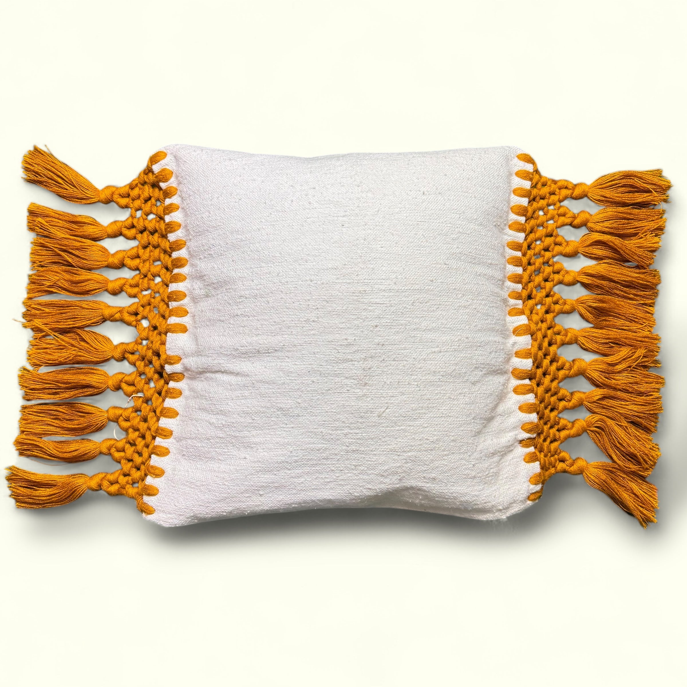 Franges et pompons orange d'une housse de coussin en macramé