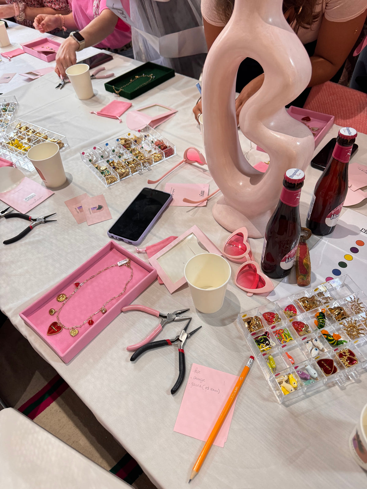 Perles, pinces et plateaux roses sur la table de l’atelier