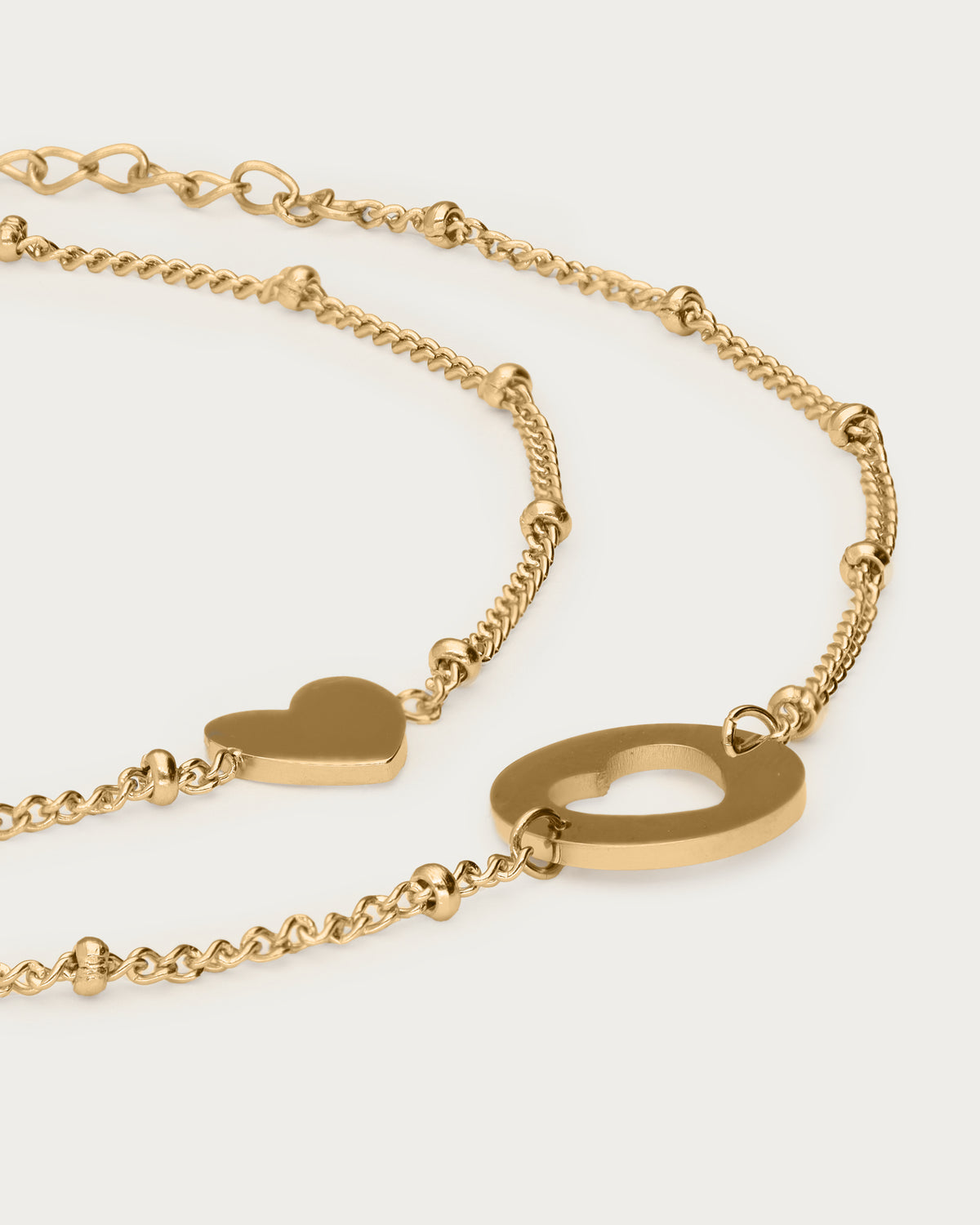 Bracelets duo mère-fille — détail des deux breloques cœur