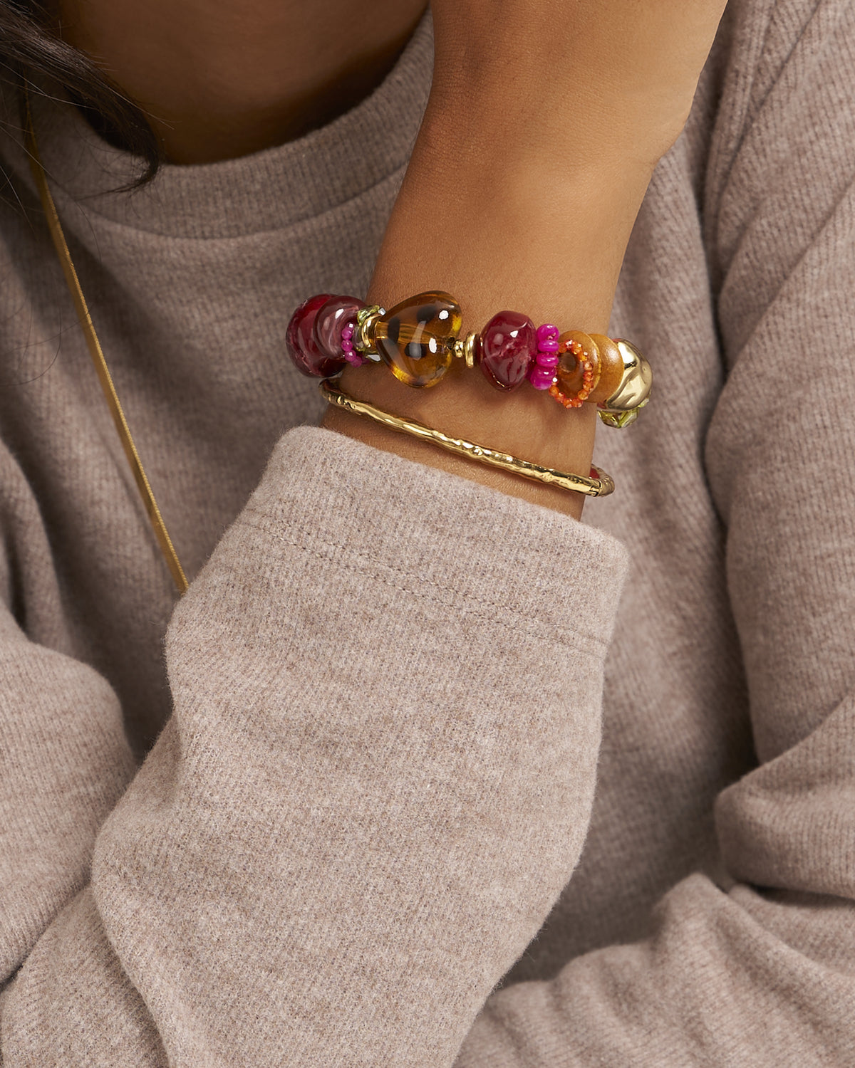 Bracelet bordeaux avec détails en forme de cœur — porté au poignet