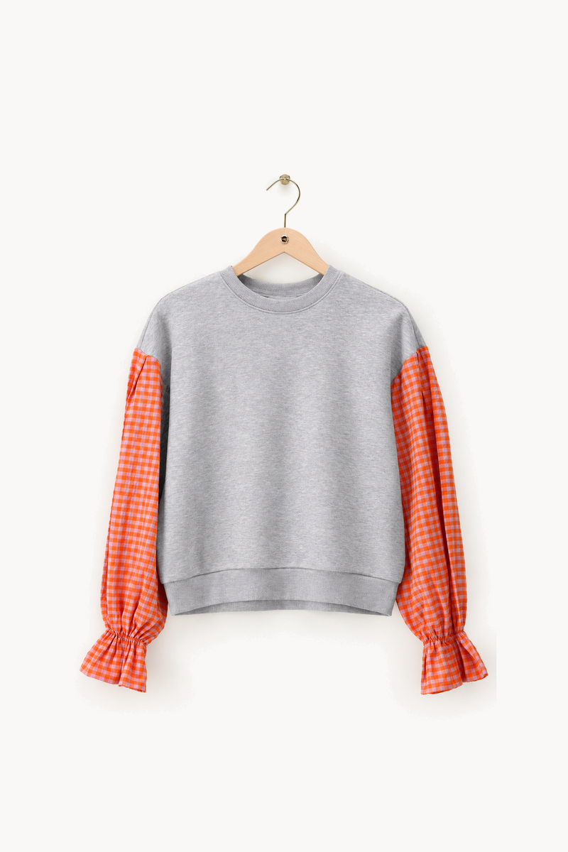 Grijze sweater met oranje geruite mouwen