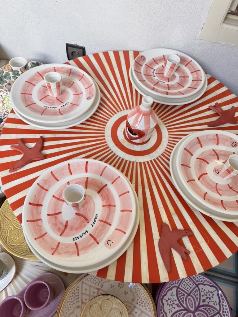 Table dressée d'assiettes peintes à la main, rayures rouges et blanches
